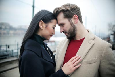 A photo of a man and woman facing each other with their foreheads touching