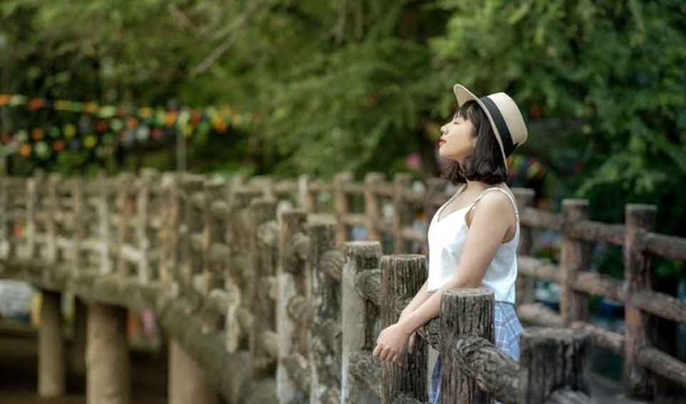 A Chinese girl waiting on a bridge.