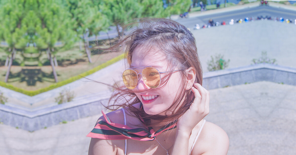 A photo of an Asian woman wearing colored sunglasses